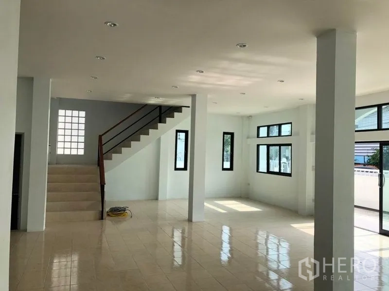 Factory for rent in Pak Kret, Nonthaburi - Bright open-plan ground floor with tiled flooring, multiple windows and a staircase.
