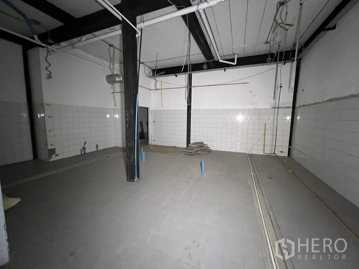 Retail Space for rent in Watthana, Bangkok - Retail hall with mural wall and suspended ceiling panels during refit.