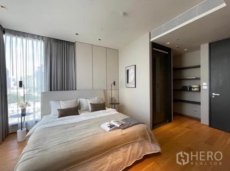 Condominium for rent in Khlong Toei, Bangkok - Second bedroom with king bed, shelving niche and wide windows bringing in light.