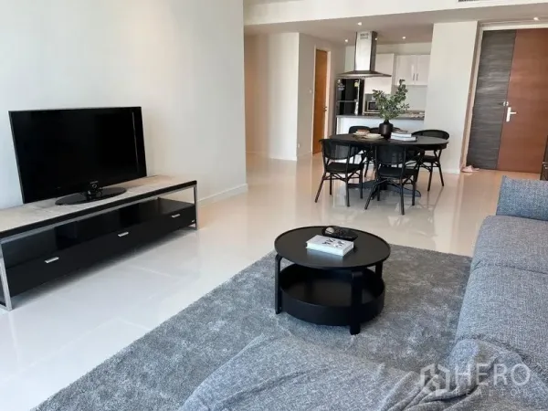 公寓 出租在Watthana, Bangkok - 客厅配电视柜、圆形茶几与亮面地砖的开放式布局。