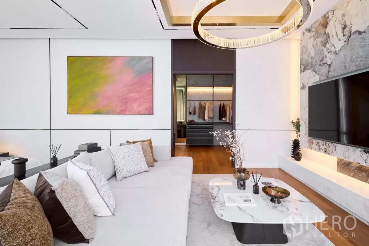 Detached House for sale in Lat Phrao, Bangkok - Master lounge with marble TV wall, ring chandelier and view to walk-in closet.