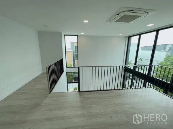 Detached House for rent or sale in Saphan Sung, Bangkok - Mezzanine family area with black metal railing and floor-to-ceiling windows.