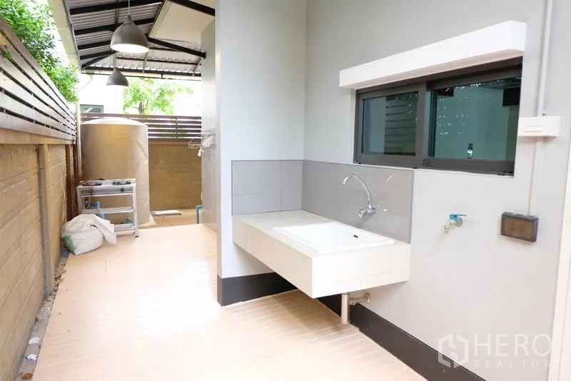 独立式住宅 出租在Prawet, Bangkok - 侧院后勤区，内置水槽与储物空间，带雨棚