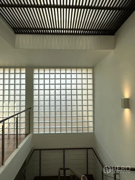 Townhouse for sale in Yan Nawa, Bangkok - Stair landing with glass-block window wall and slatted ceiling bringing in soft daylight.