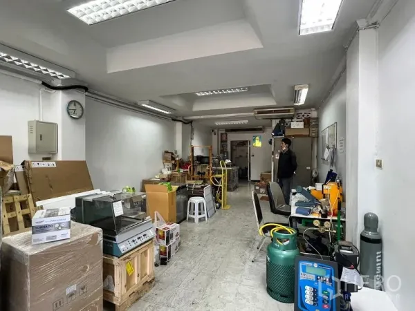 Shophouse for rent in Watthana, Bangkok - Open-plan shophouse interior with white walls, bright fluorescent lighting, tiled floor, workstations and storage, ideal for retail or café layout in Thonglor, Bangkok.