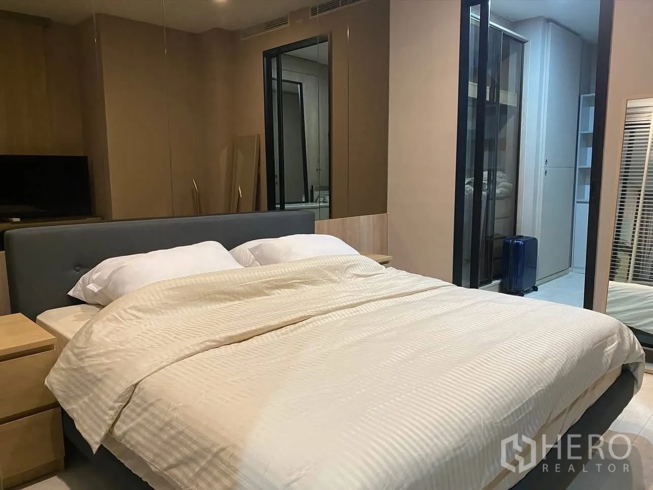 公寓 for rent in Pathum Wan, Bangkok - 主卧配软包床、镜面衣柜，并可通往步入式衣帽区。
