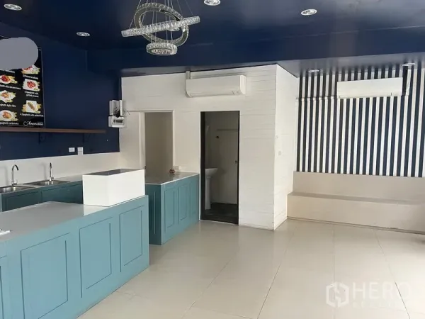 Retail Space for rent in Watthana, Bangkok - Open‑plan retail area showing built‑in counters, restroom door and multiple air‑conditioning units.