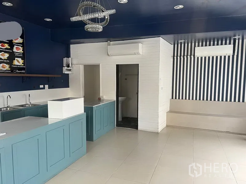 Retail Space for rent in Watthana, Bangkok - Open‑plan retail area showing built‑in counters, restroom door and multiple air‑conditioning units.