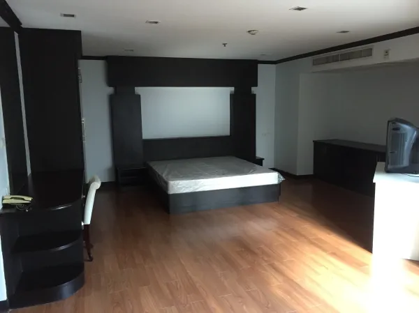 公寓 出租在Watthana, Bangkok - 宽敞卧室，木地板与深色内置家具，带床架。