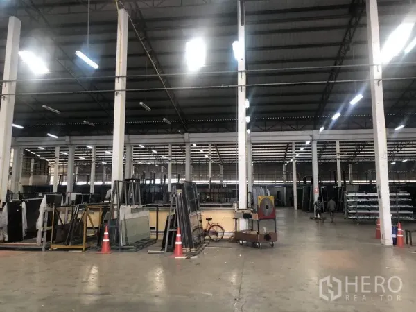 货栈 出租在Nonthaburi - 仓储区，混凝土地面、高柱网格和货架设备