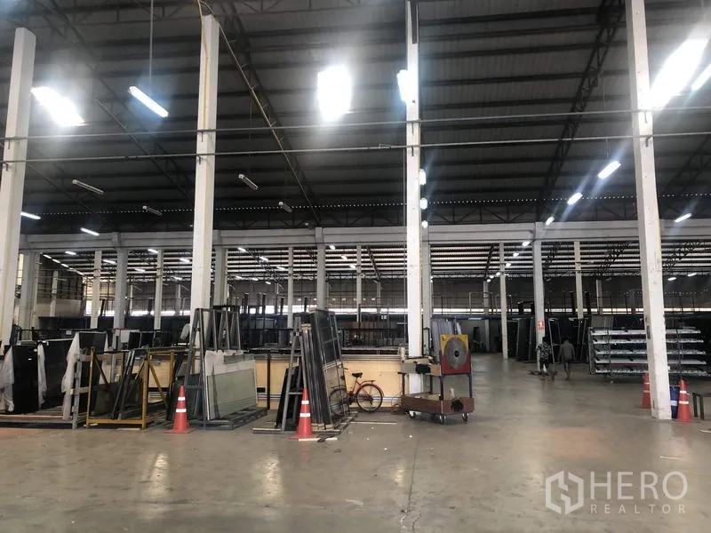 货栈 出租在Nonthaburi - 仓储区，混凝土地面、高柱网格和货架设备