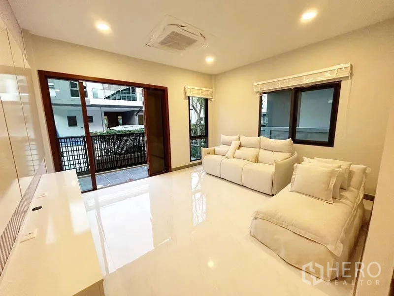 บ้าน ให้เช่าในBang Phli, Samut Prakan - ห้องนั่งเล่นโทนขาว โซฟาเปิดออกลานระเบียงด้วยประตูกระจกเลื่อน