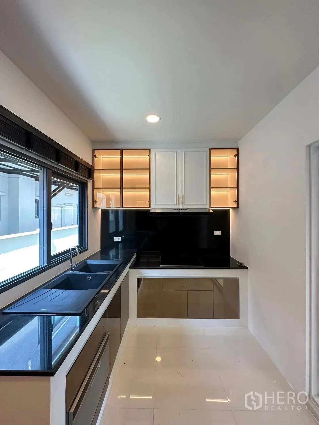 独栋房屋 for rent in Bang Phli, Samut Prakan - 现代L形厨房，黑色石材台面、水槽与带灯吊柜。