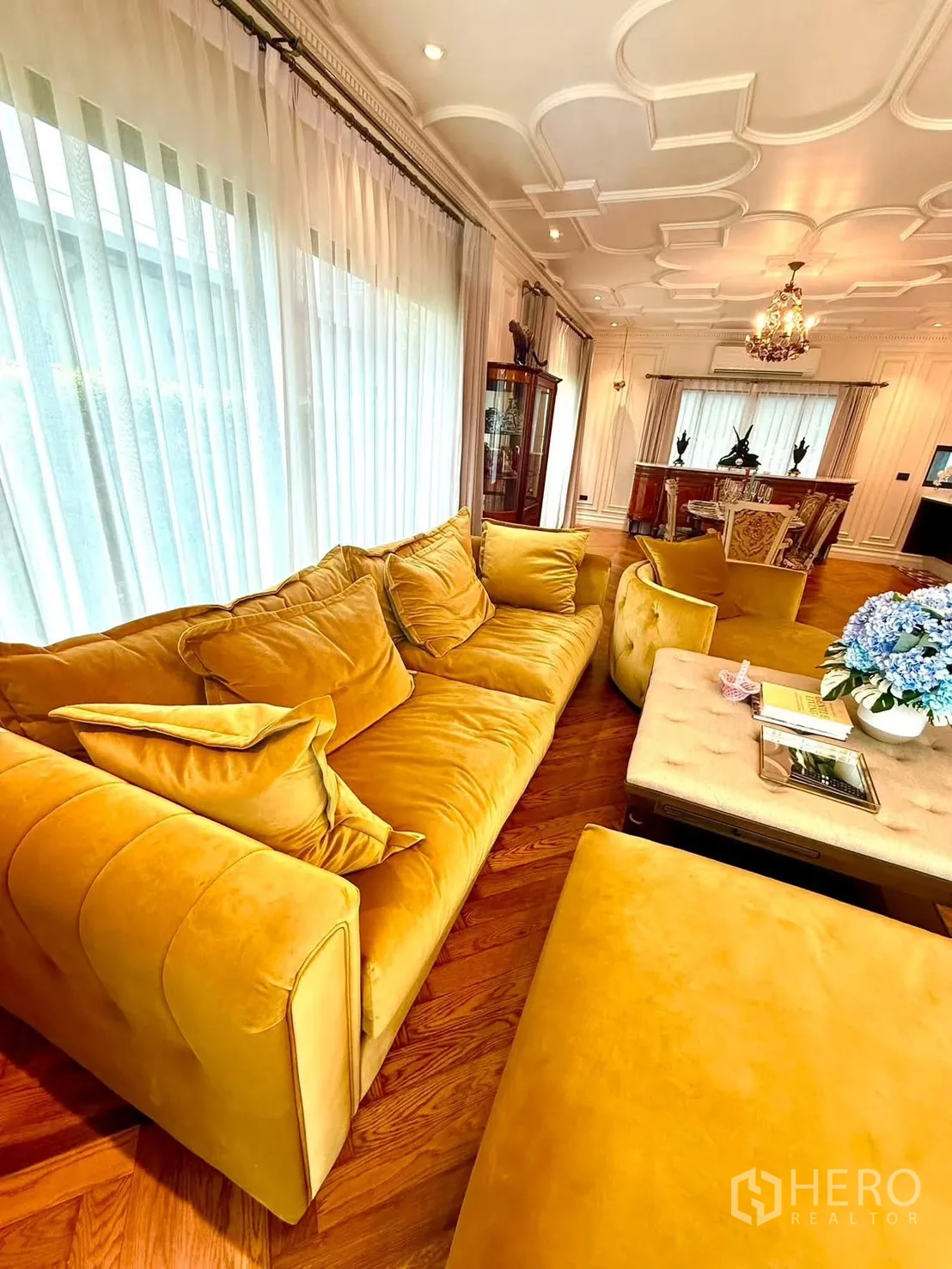 Detached House for rent in Bang Kapi, Bangkok - Bright living area with mustard sofa by full-length curtains.
