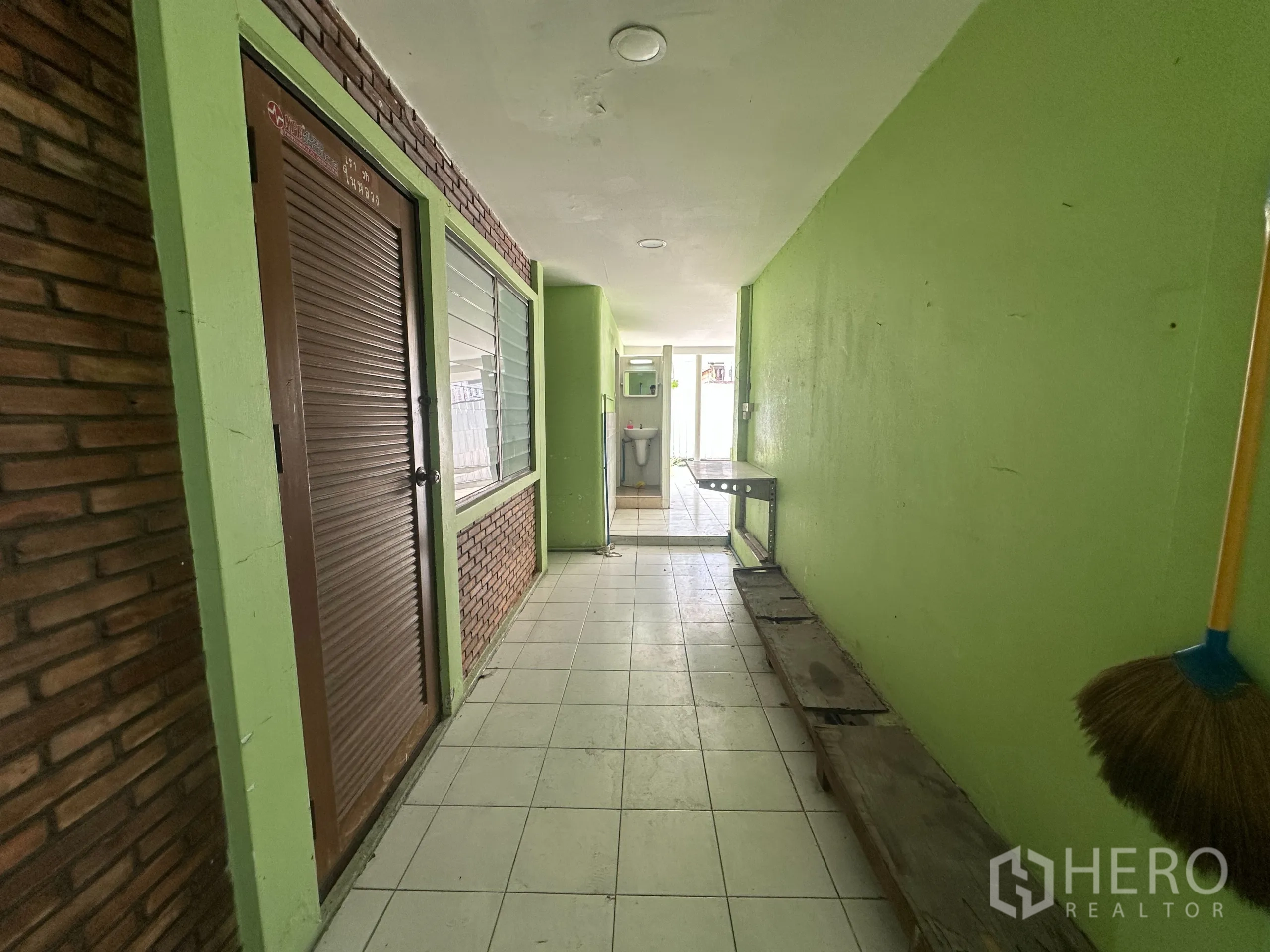 Retail Space for rent in Watthana, Bangkok - Covered side corridor with green walls and brick accents leading to service area.
