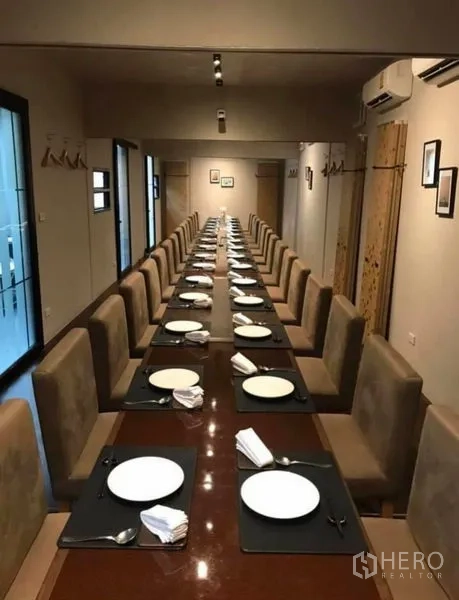 Retail Space for rent in Khlong Toei, Bangkok - Long private dining room set with plates and upholstered chairs.