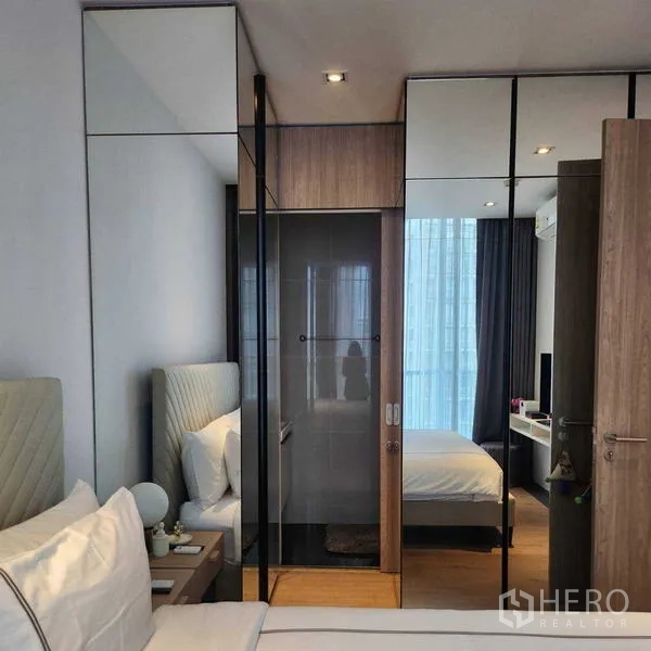 Condominium for rent - Bedroom featuring mirrored wardrobes and glass sliding door to the bathroom.