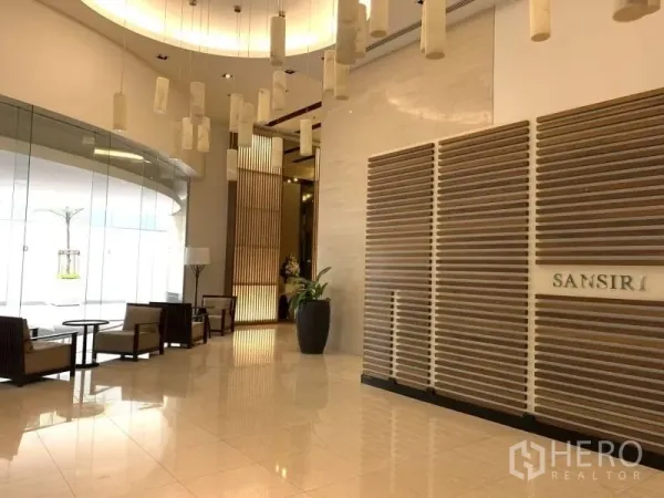 Condominium for rent in Khlong Toei, Bangkok - Elegant condo lobby with pendant lights, seating area and Sansiri signage.