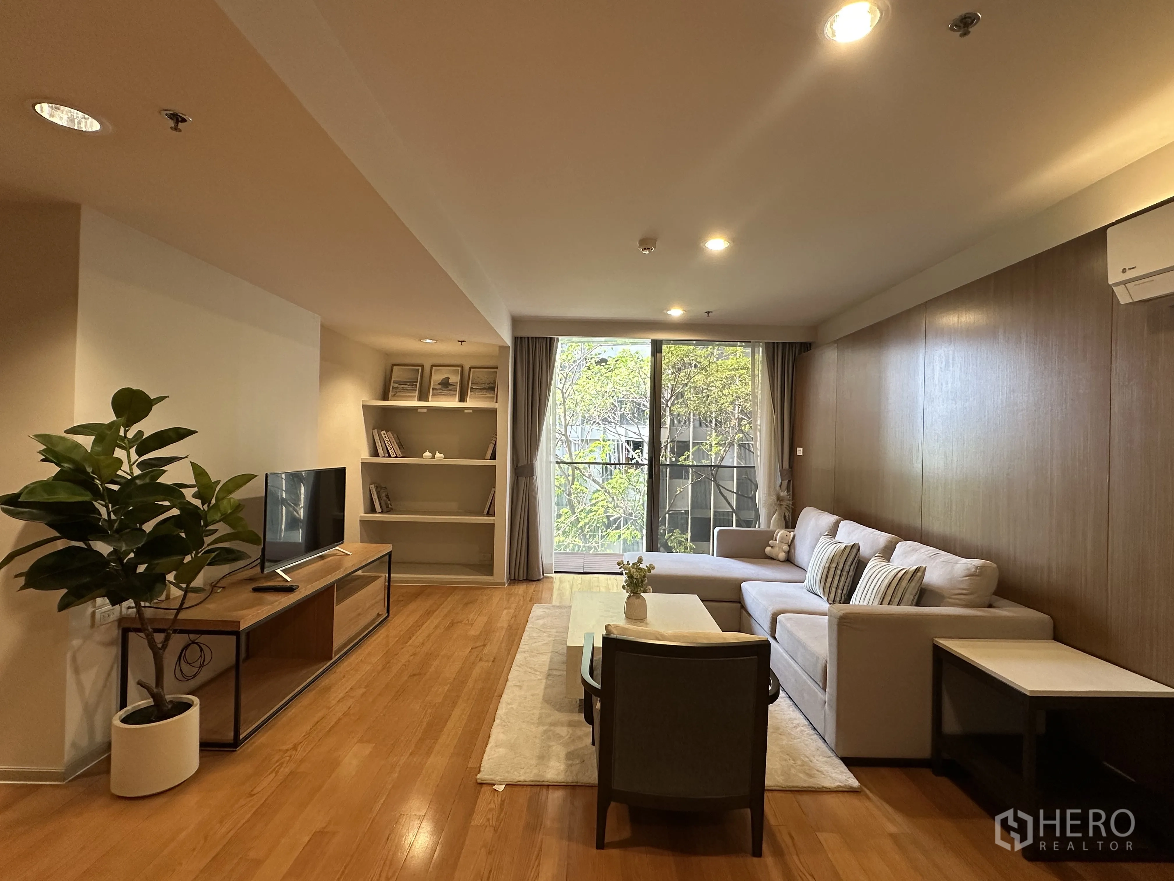 公寓 for rent in Khlong Toei, Bangkok - 宽敞客厅，L形沙发、电视柜并连接阳台。