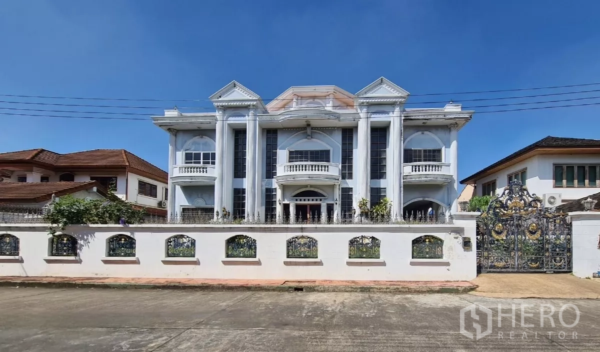 Detached House for sale in Chatuchak, Bangkok - Grand three-storey neoclassical facade behind a white wall with ornate gate.