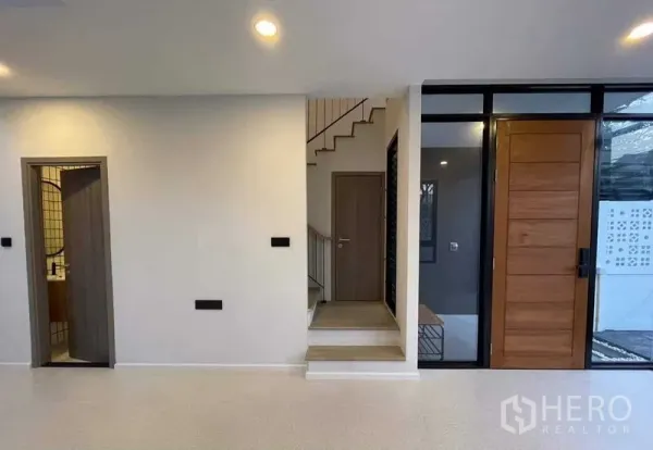 带办公室的家 出售在Lat Phrao, Bangkok - 入口门厅，木门、楼梯与客卫