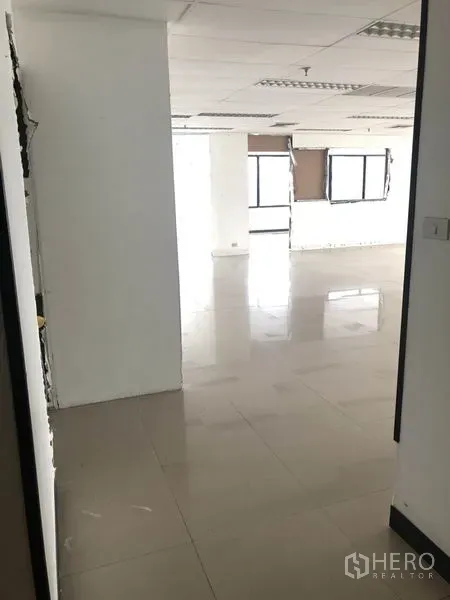 办公空间 出租在Watthana, Bangkok - 走廊通向开放式办公区，白墙与瓷砖地面
