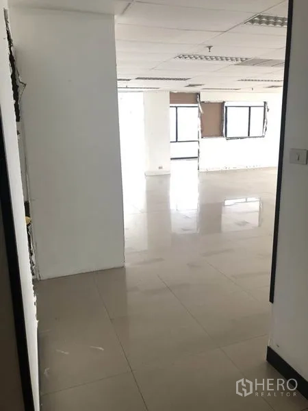 办公空间 出租在Watthana, Bangkok - 走廊通向开放式办公区，白墙与瓷砖地面
