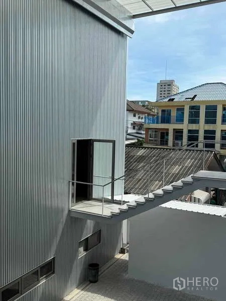 Home Office for rent or sale - Metal-clad exterior volume with a narrow open-air stair leading to a side door.