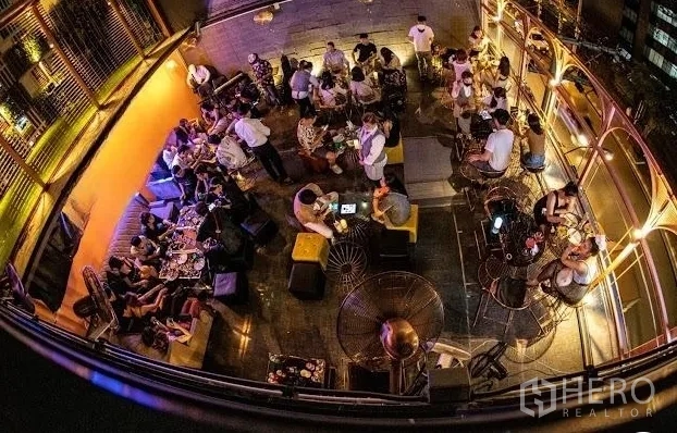 Retail Space for rent - Overhead view of a rooftop lounge with tables, warm ambient lighting and city outlook, designed for social gatherings.