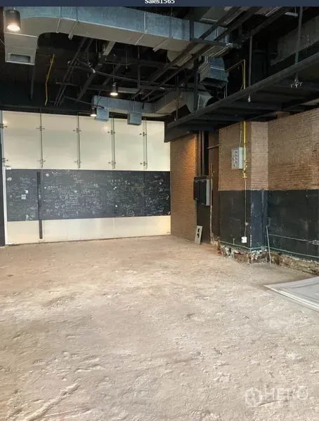 Retail Space for rent in Khlong Toei, Bangkok - Angle view of empty retail space showing industrial ceiling, utility panels and unfinished flooring.