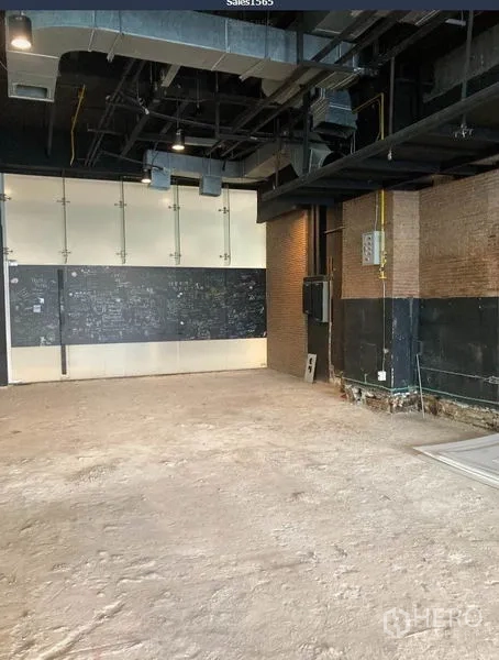 Retail Space for rent in Khlong Toei, Bangkok - Angle view of empty retail space showing industrial ceiling, utility panels and unfinished flooring.