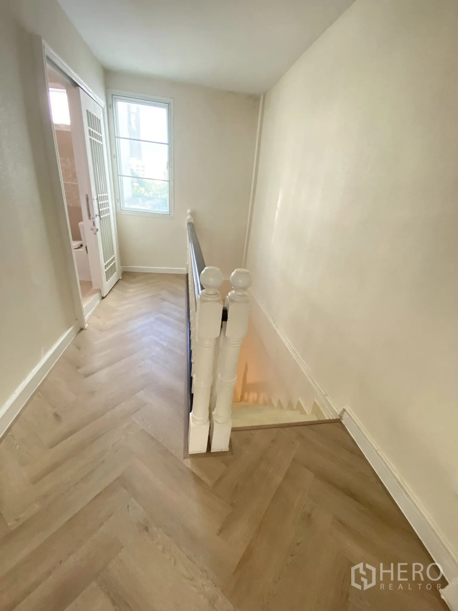 家庭办公室 for rent in Pathum Wan, Bangkok - 采光良好的楼梯平台，设窗与浅色木地板通往上层。