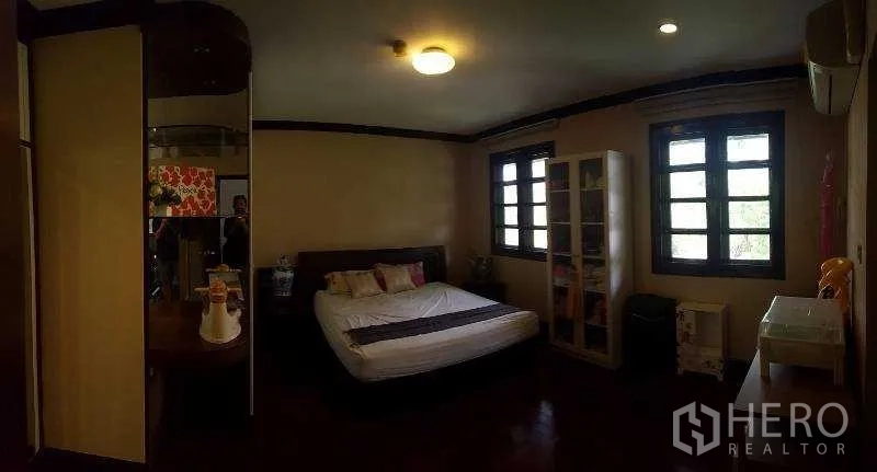 独立式住宅 出租在Bang Phli, Samut Prakan - 卧室配深色木地板、置物架与双窗。