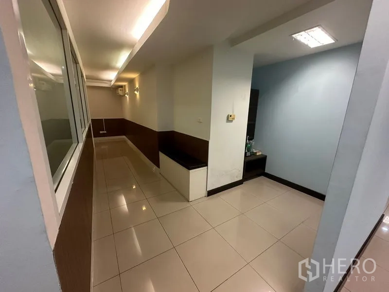 Office Space for sale - Corridor with built-in bench seating and downlights connecting rooms.