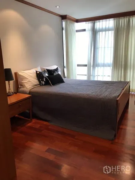 公寓 出租在Watthana, Bangkok - 明亮的次卧，配大床与转角窗，纱帘与木地板