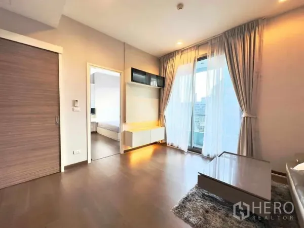 คอนโด ขายในRatchathewi, Bangkok - ห้องนั่งเล่นสว่าง มีหน้าต่างเต็มบาน ระเบียง และตู้ทีวีบิลท์อิน ที่คิว อโศก