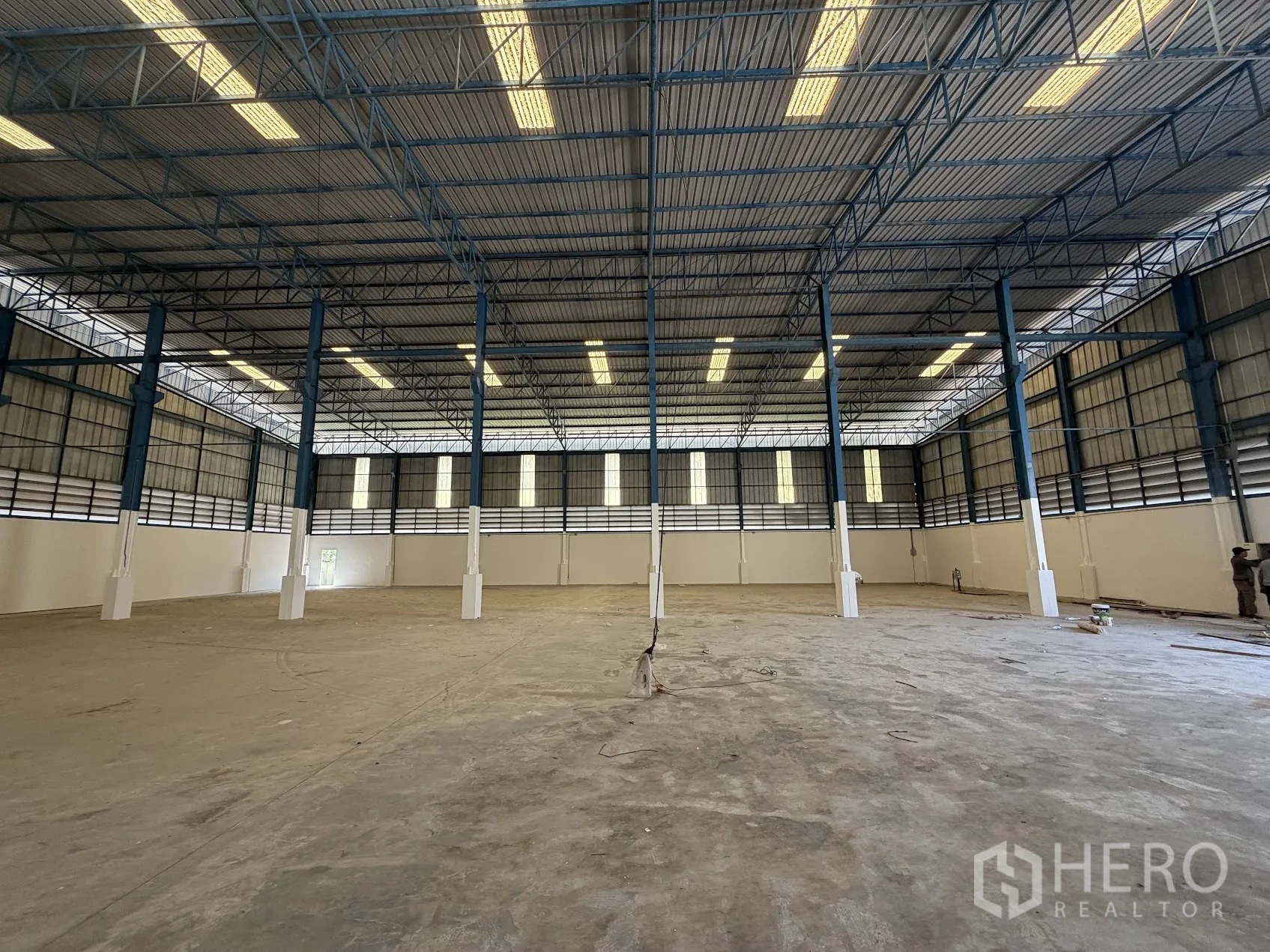 โรงงาน for rent in Bang Sao Thong, Samut Prakan - มุมมองกว้างของฮอลล์คลังสินค้า มีเสาเหล็กหลายต้นและไฟส่องสว่างด้านบน