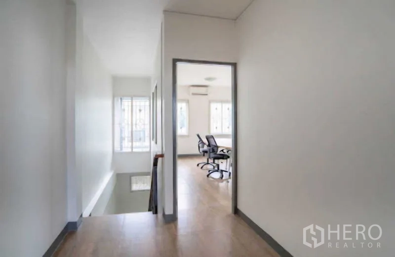 Home Office for rent or sale in Lat Krabang, Bangkok - Upper-floor hallway leading to meeting room with wood-look flooring.