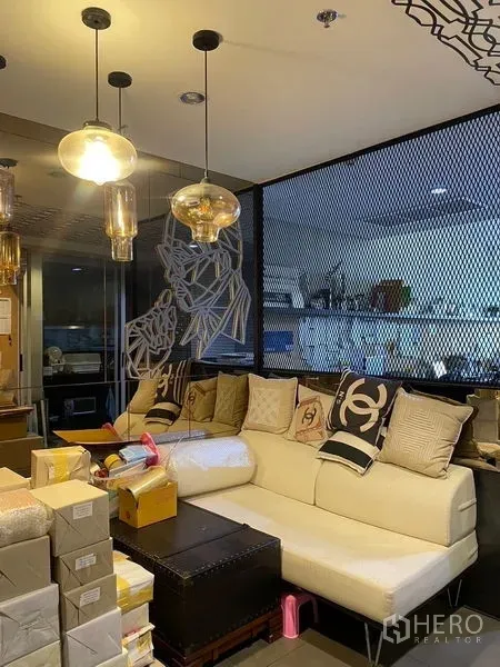 办公空间 出租在Phaya Thai, Bangkok - 现代办公室的接待区，米色沙发、吊灯与网格玻璃隔断。