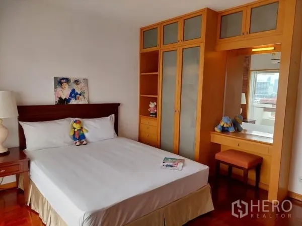 Apartment for rent - Sathon Bangkok apartment bedroom with built-in wooden wardrobe, dressing table and hardwood floor.