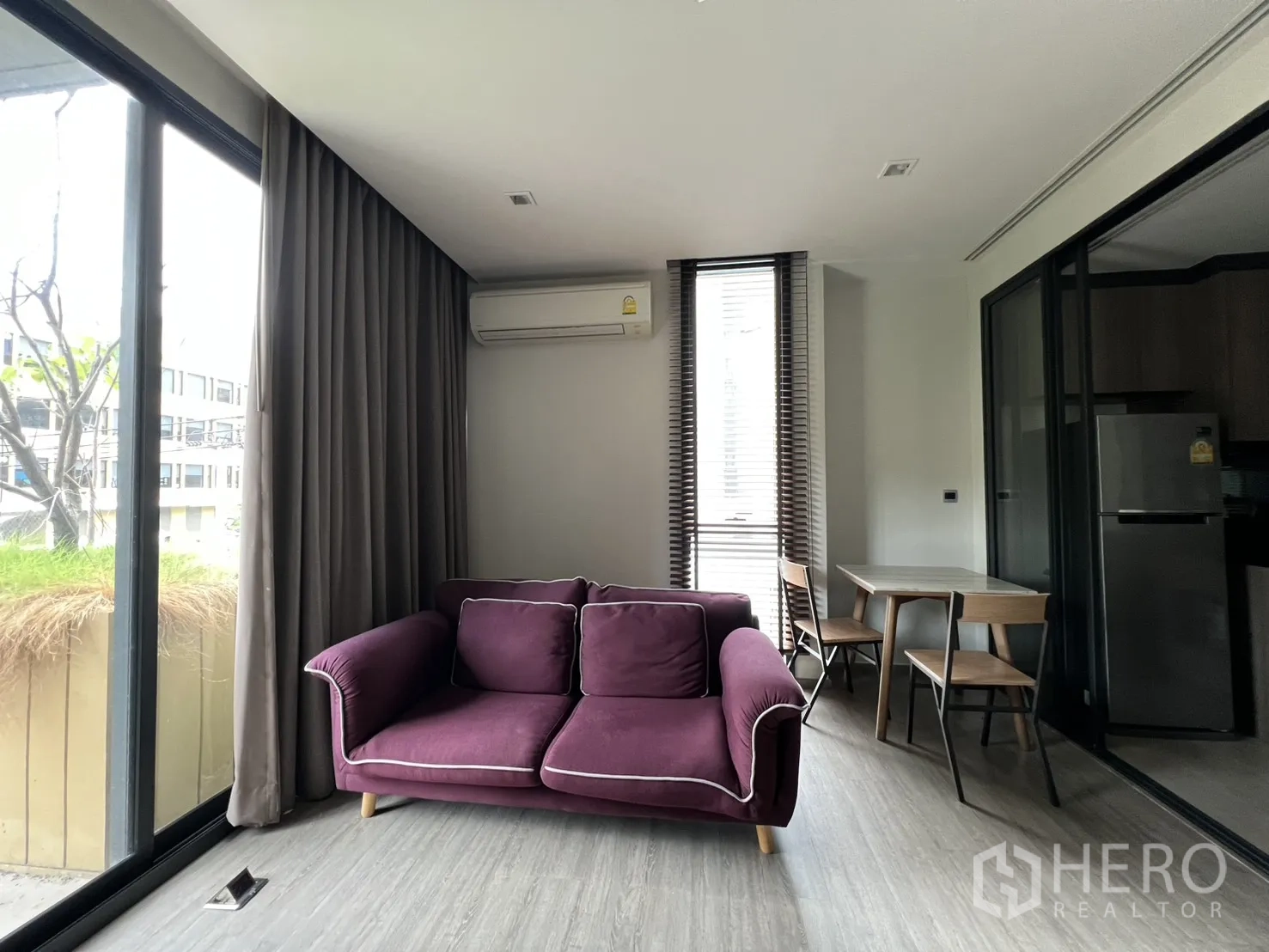 คอนโด for rent in Watthana, Bangkok - ห้องนั่งเล่นสว่างด้วยหน้าต่างสูงจรดเพดาน โซฟาสีม่วง และโต๊ะทานข้าว