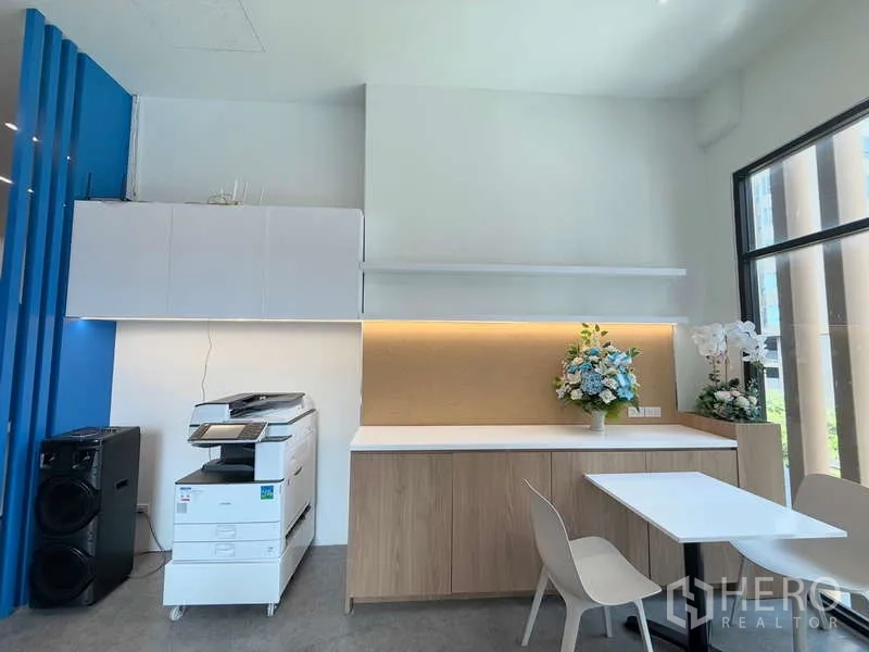 Office Space for rent in Huai Khwang, Bangkok - Printing corner with copier, storage cabinets, small table and a tall window bringing in natural light.