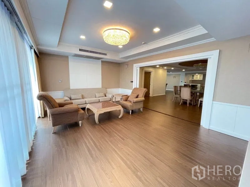 公寓 出租在Watthana, Bangkok - 次客厅，大片窗户、水晶灯，与通向餐厅的推拉门。