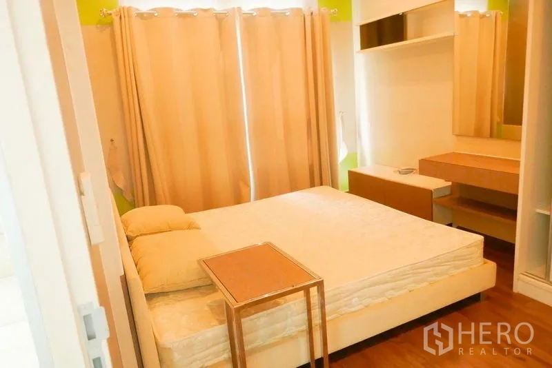 Condominium for rent or sale in Khlong San, Bangkok - Bedroom with queen bed, blackout curtains and built-in vanity.
