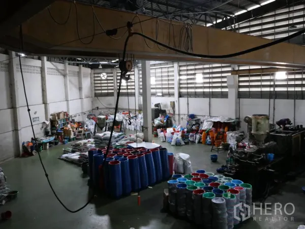 工厂 出租或出售在Bang Khun Thian, Bangkok - 生产车间，高挑屋顶，地面堆放塑料制品及天车线路。