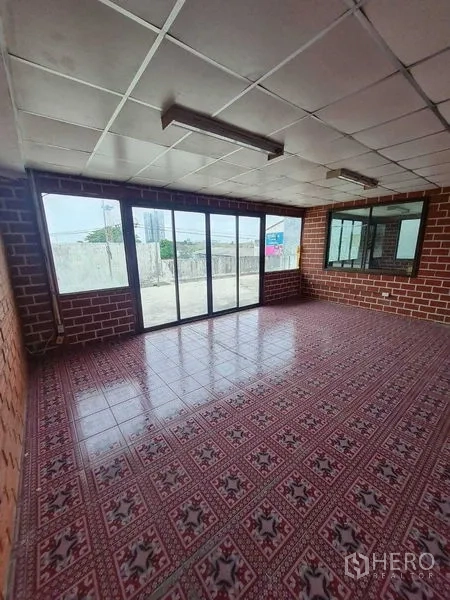 Warehouse for rent in Bang Yai, Nonthaburi - Bright office with patterned tiles, brick-style walls and full-height sliding glass doors.