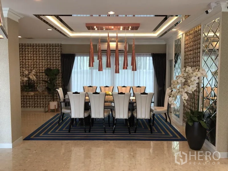 Detached House for rent or sale in Saphan Sung, Bangkok - Ten-seat dining room with statement pendant lighting and a blue area rug.