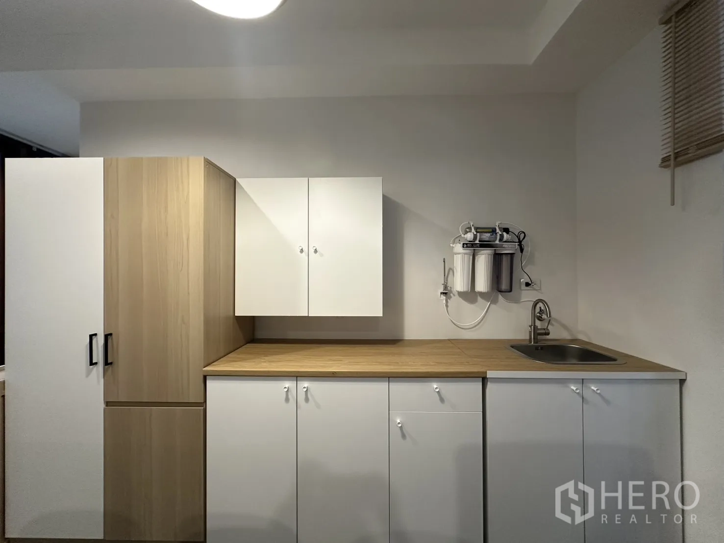 公寓 for rent in Pathum Wan, Bangkok - 茶水厨房配白色柜体、木纹台面及净水系统。
