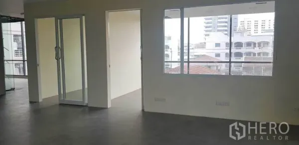 Office Space for rent in Suan Luang, Bangkok - Partitioned office area with sliding glass door and wide windows overlooking nearby buildings.