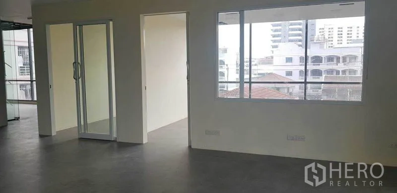 Office Space for rent in Suan Luang, Bangkok - Partitioned office area with sliding glass door and wide windows overlooking nearby buildings.